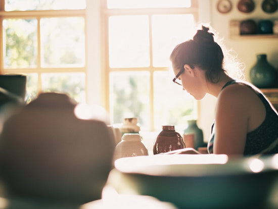 Woman in her studio crafting Etsy urns.